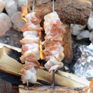 bacon on skewers over campfire