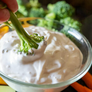 Dunking broccoli in blue cheese dip.