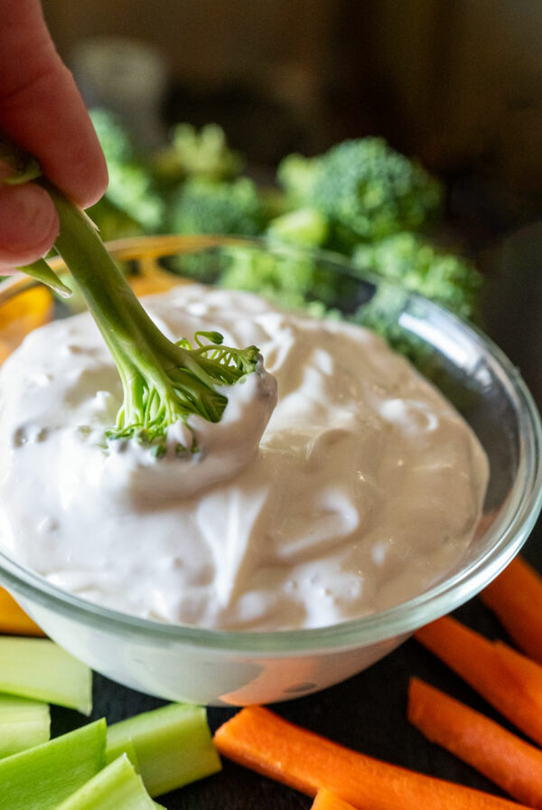 Dunking broccoli in blue cheese dip.