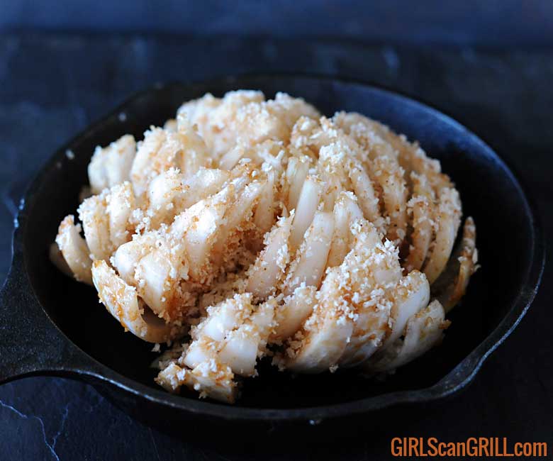 sliced onion in skillet coated with breadcrumbs