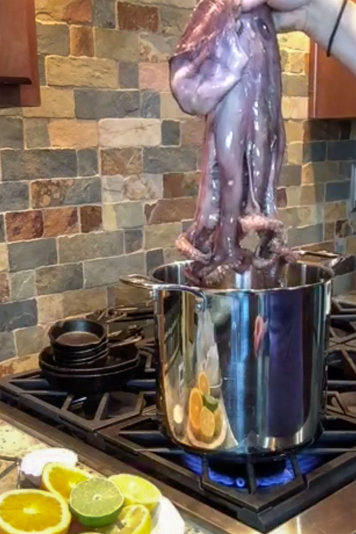 dipping whole octopus in pot of water to create curled tentacles. 