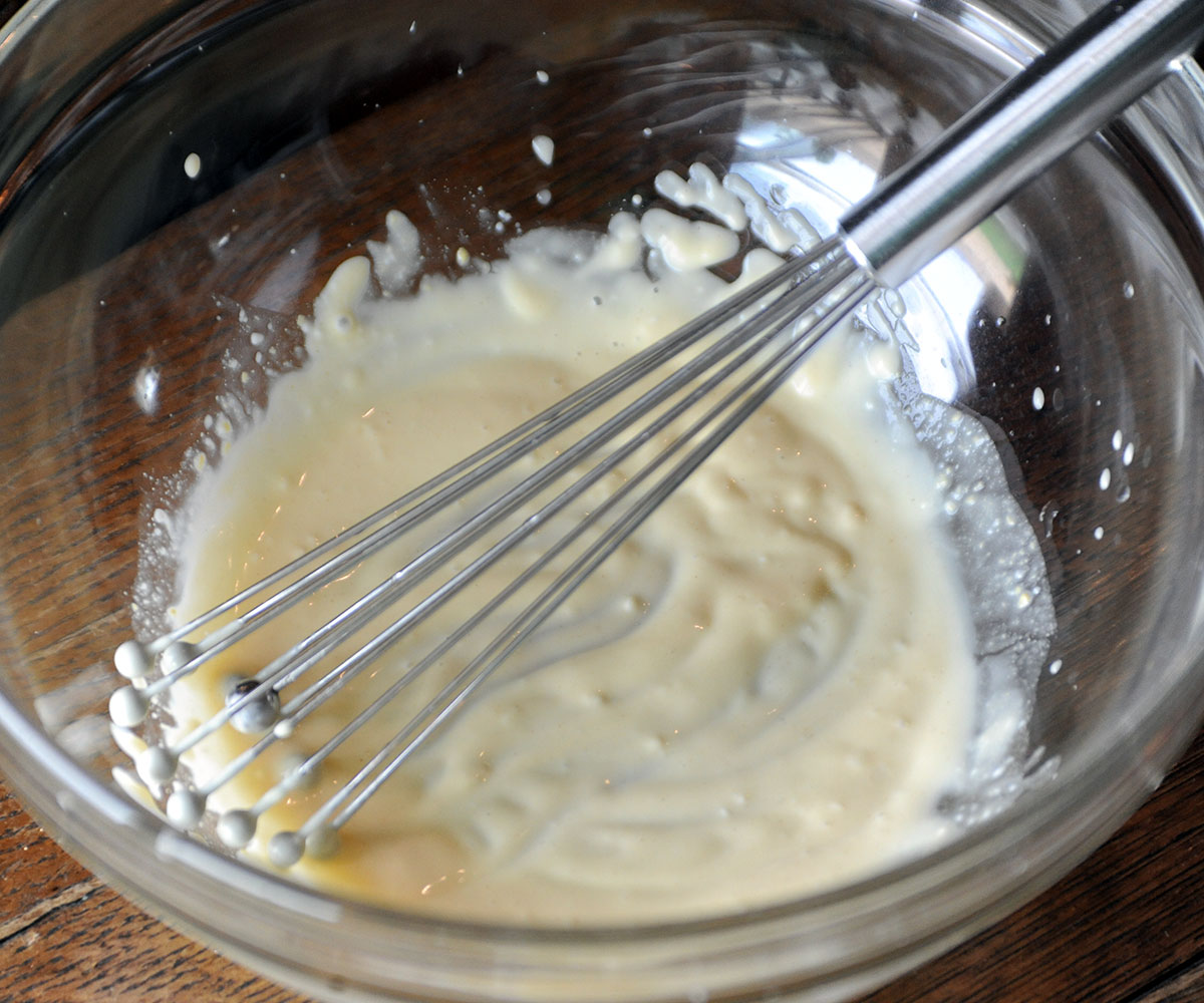 tuna salad dressing mixed in bowl with whisk.