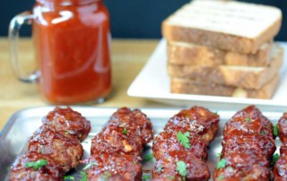 tray of meatballs near jar of sauce and bread slices