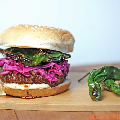 burger topped with red cabbage and shishito peppers with white background