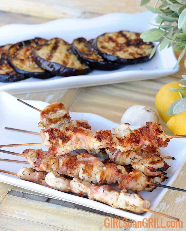 white platter of grilled chicken and grilled eggplant above