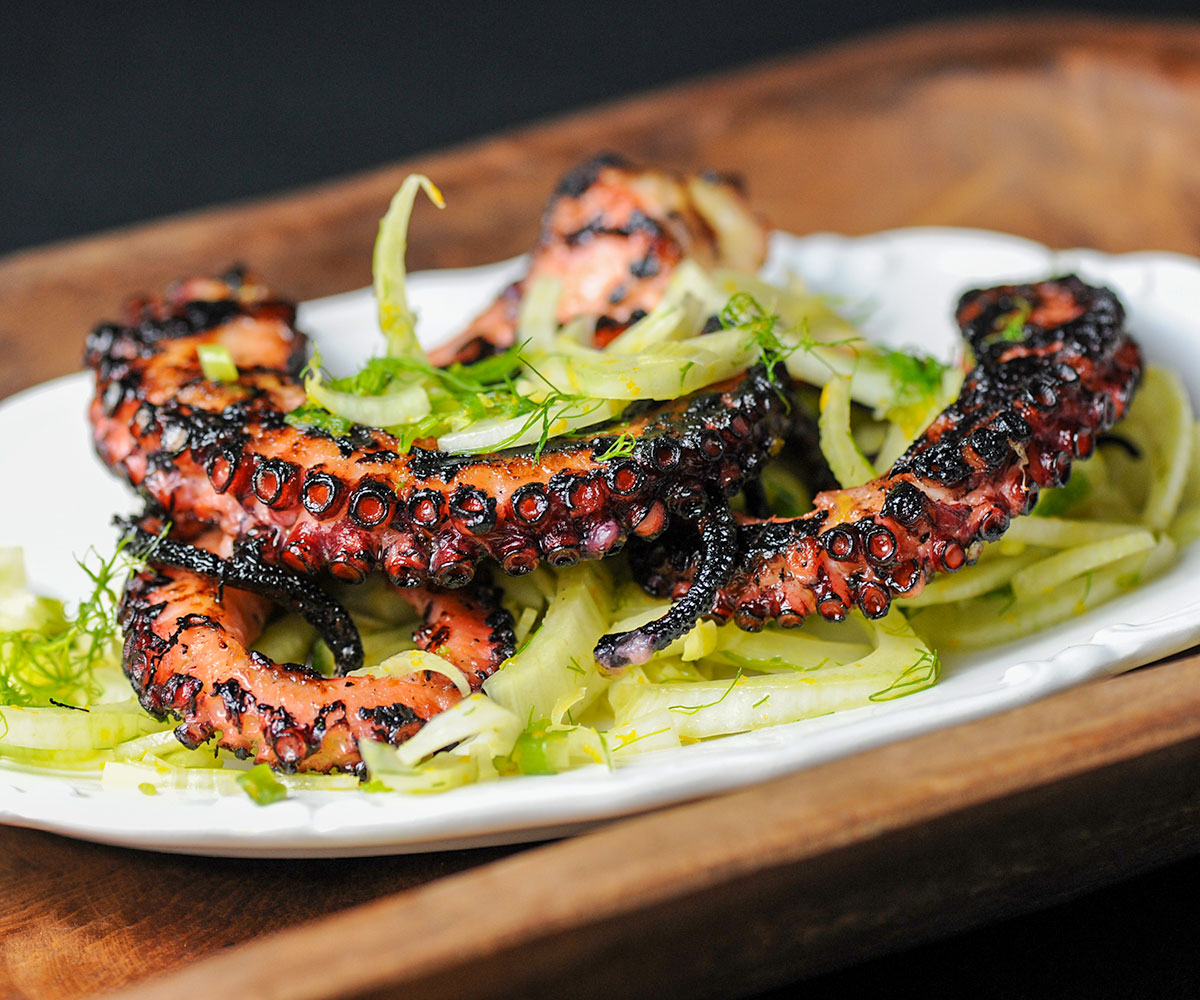 grilled octopus on a bed of greens.