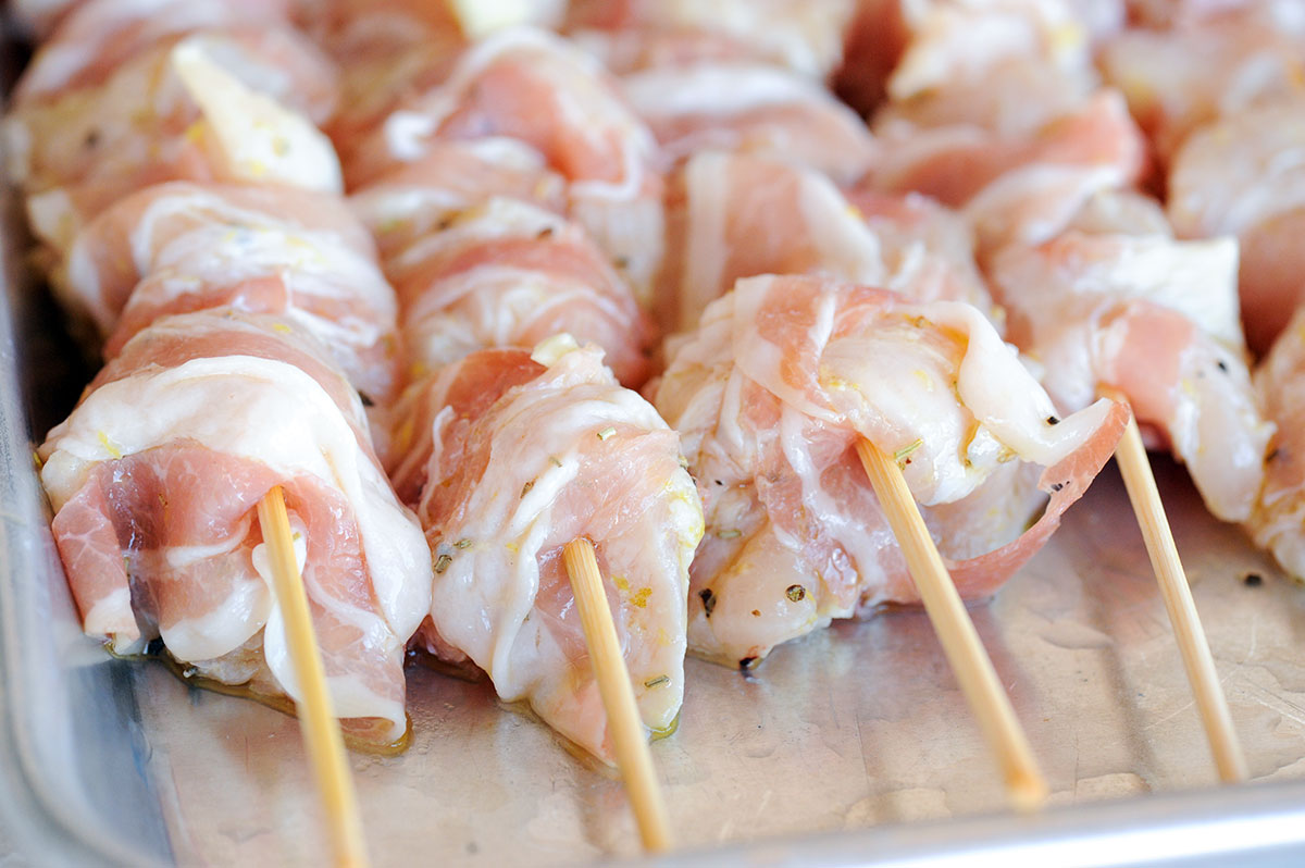 chicken on skewers wrapped in pancetta.