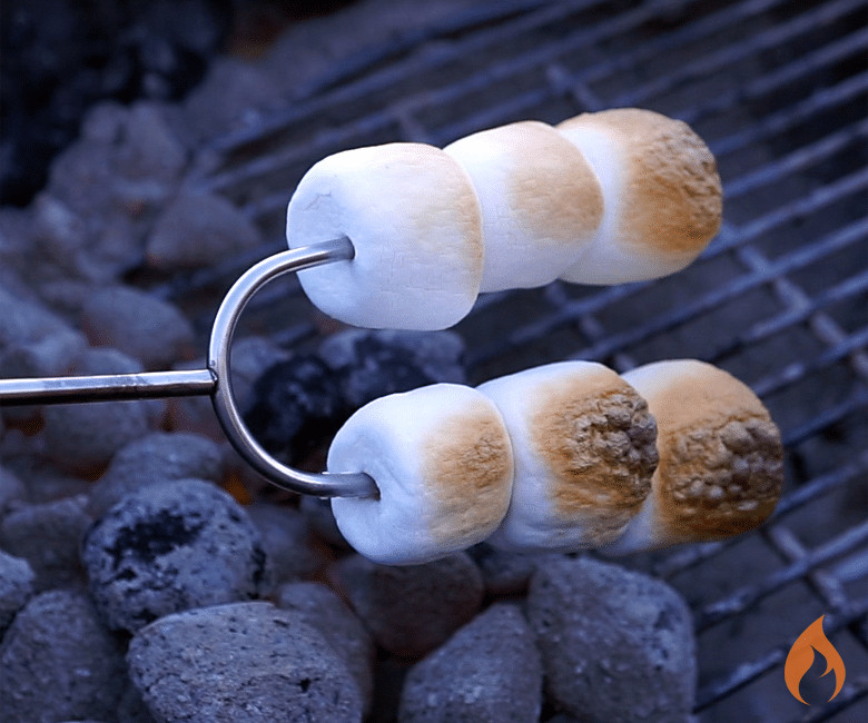 six marshmallows roasting over coals