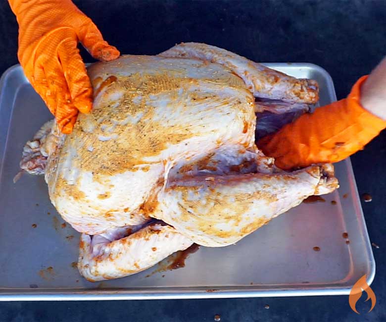raw turkey getting rub applied by hand