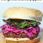 teriyaki burger on wood platter topped with red cabbage and shishito peppers.