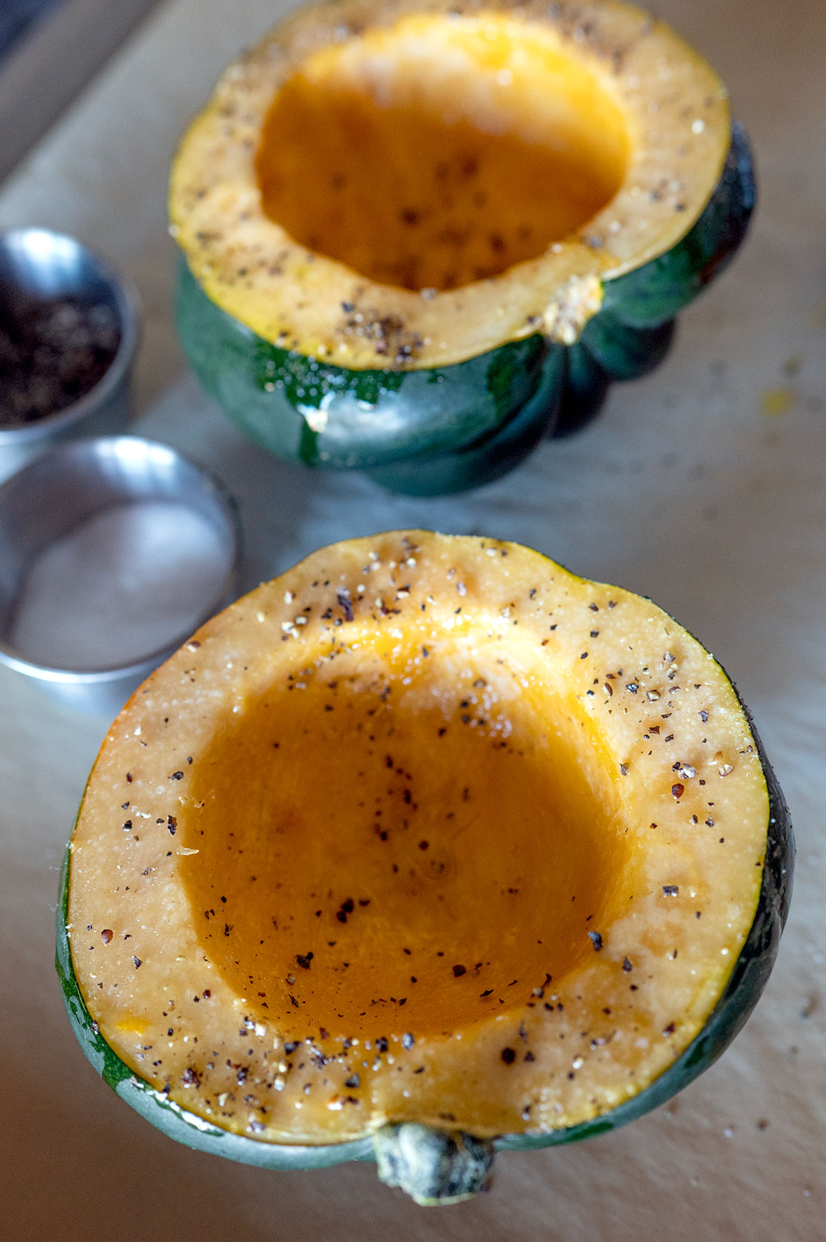Acorn squash cut in half and seasoned with salt and pepper.