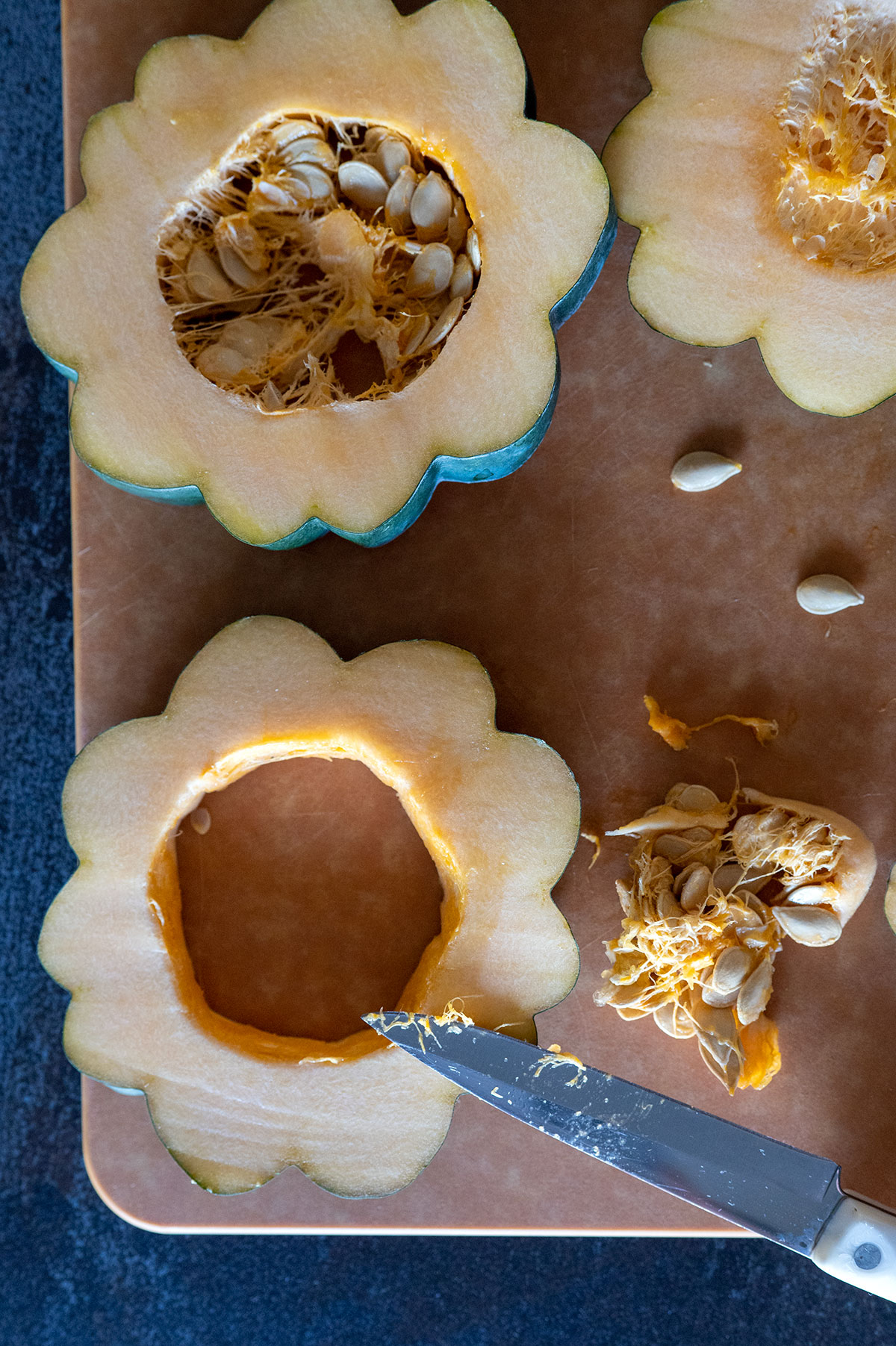 pairing knife on acorn squash showing seeds removed from center.