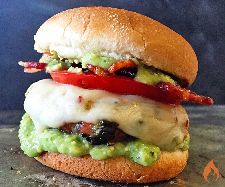 burger topped with tomatoes, white cheese and avacado salsa
