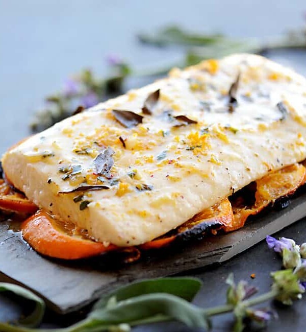 grilled halibut resting on tangarine slices with sage flowers