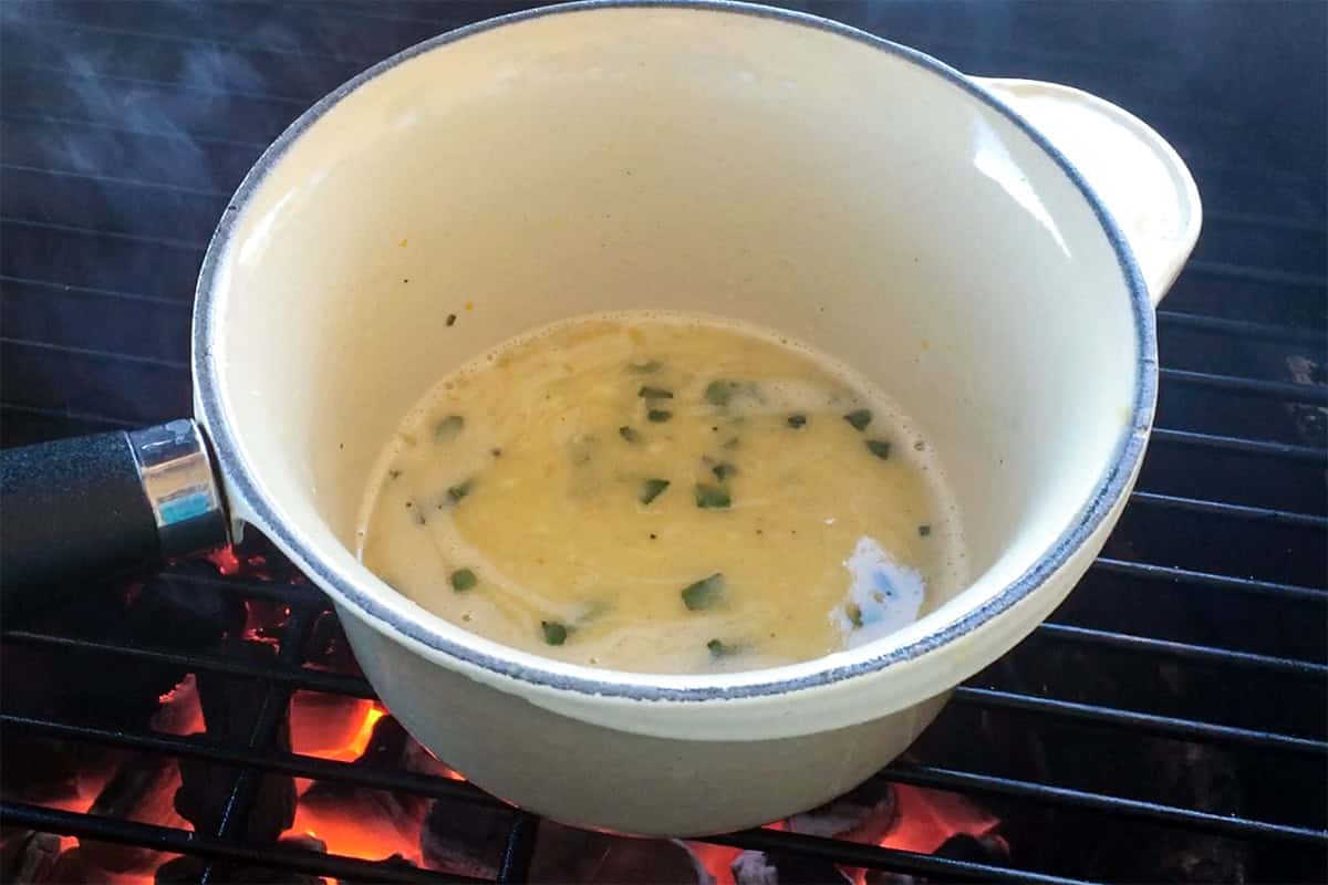 Butter herb sauce in pot on grill.
