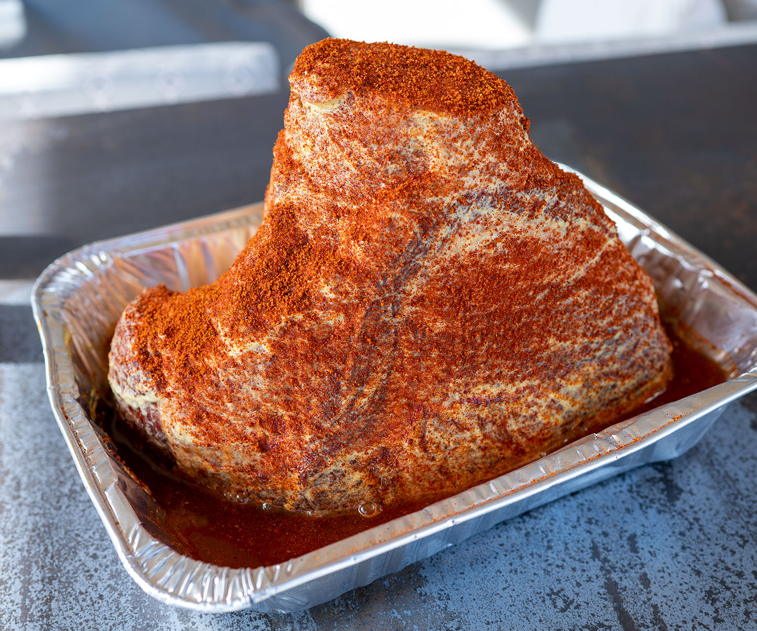 ham in pan rubbed with mustard and seasoning