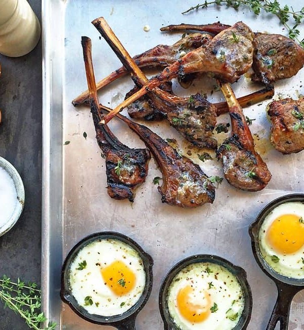 grilled lamb chops on pan with 3 mini skillets of fried eggs