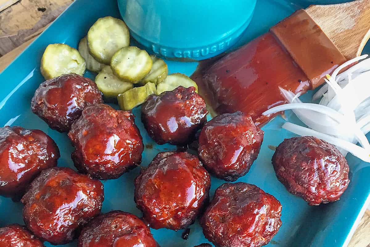BBQ meatballs on platter with pickles.