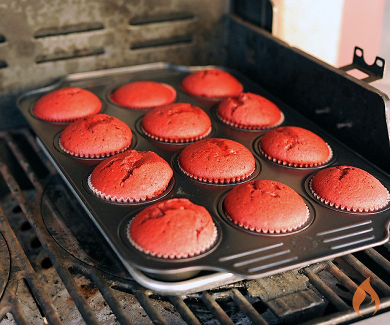 muffin tin of red cupcakes on a grill