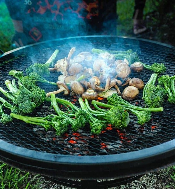 mushrooms and broccolini grilling on fire pit.