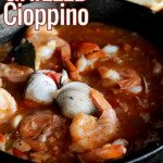 cast iron pot of grilled cioppino with toasted bread