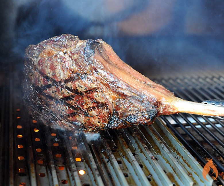 cowboy ribeye searing on its side on grill