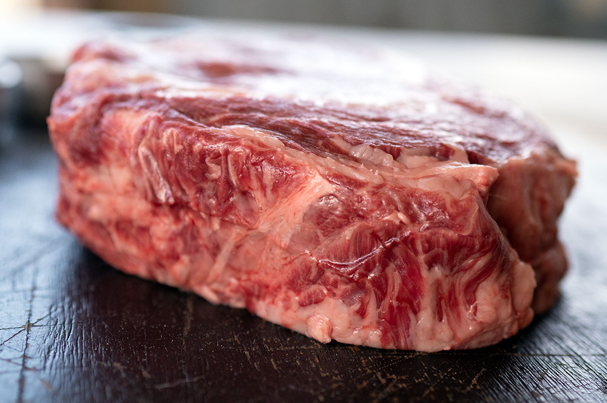 side of cowboy ribeye showing thickness.