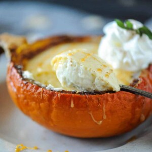 spoon scooping cheesecake out of a pumpkin.
