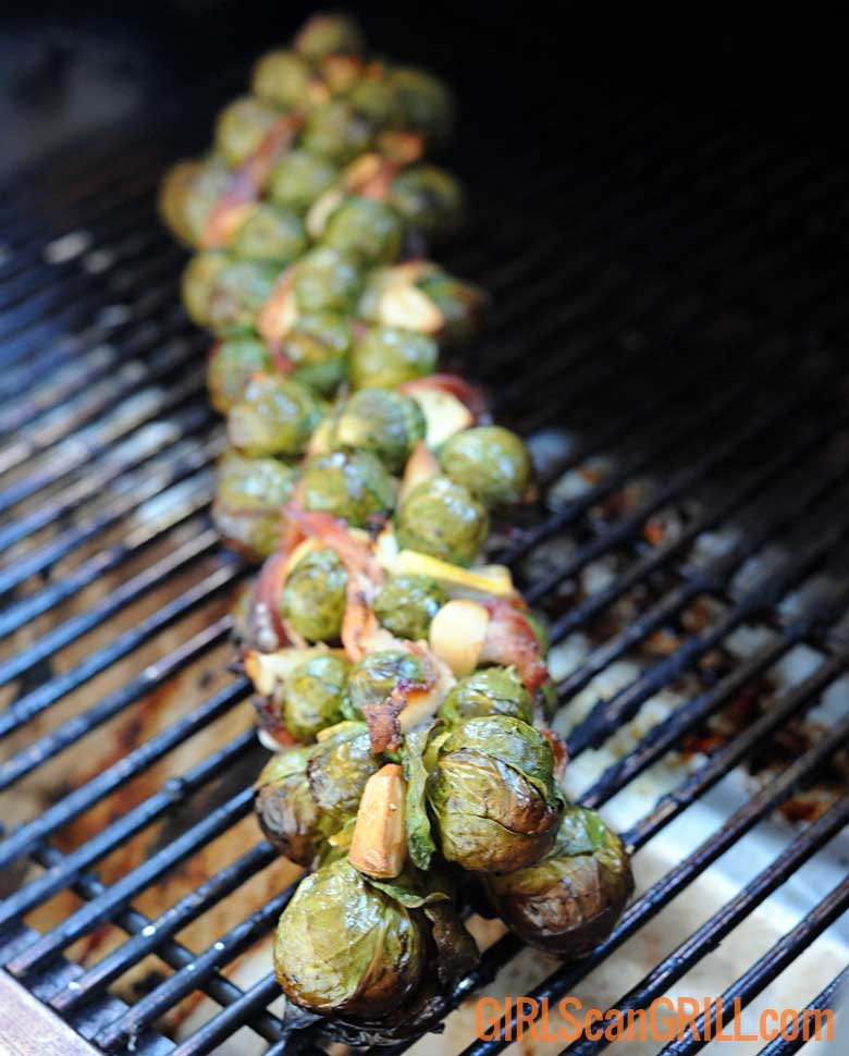 Brussels sprouts stalk with bacon weave on grill