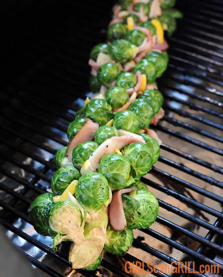 Brussels sprouts stalk with bacon weave on grill