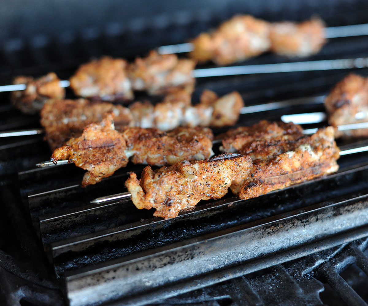skewers of alligator on a grill.