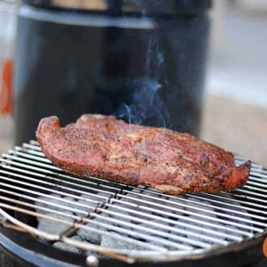 tri tip on grill grate with barrel house cooker in background