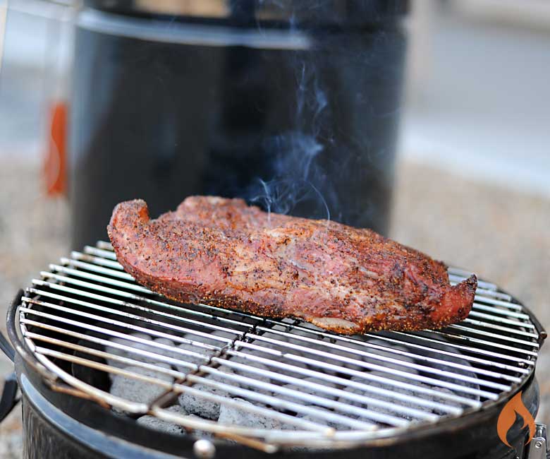 tri tip on grill grate with barrel house cooker in background