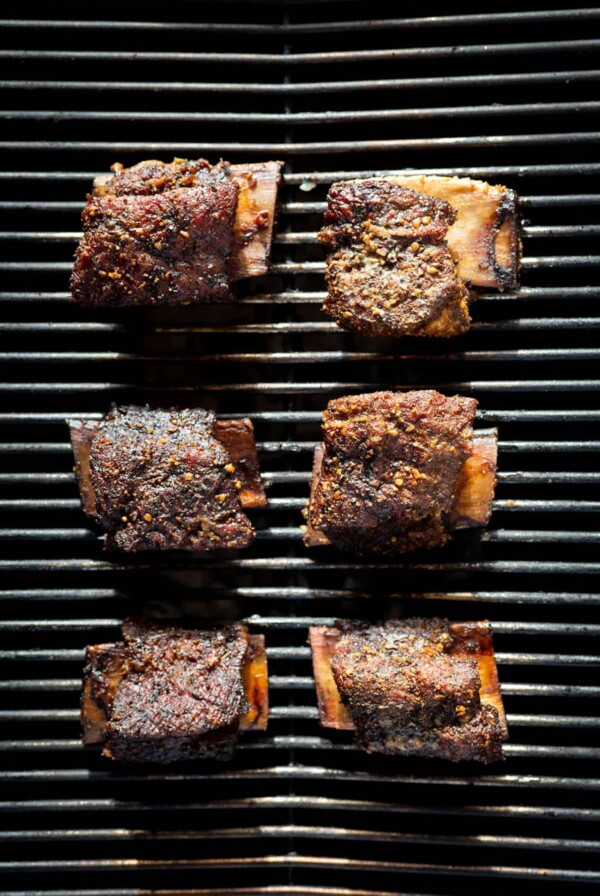 6 short ribs smoking on grill.