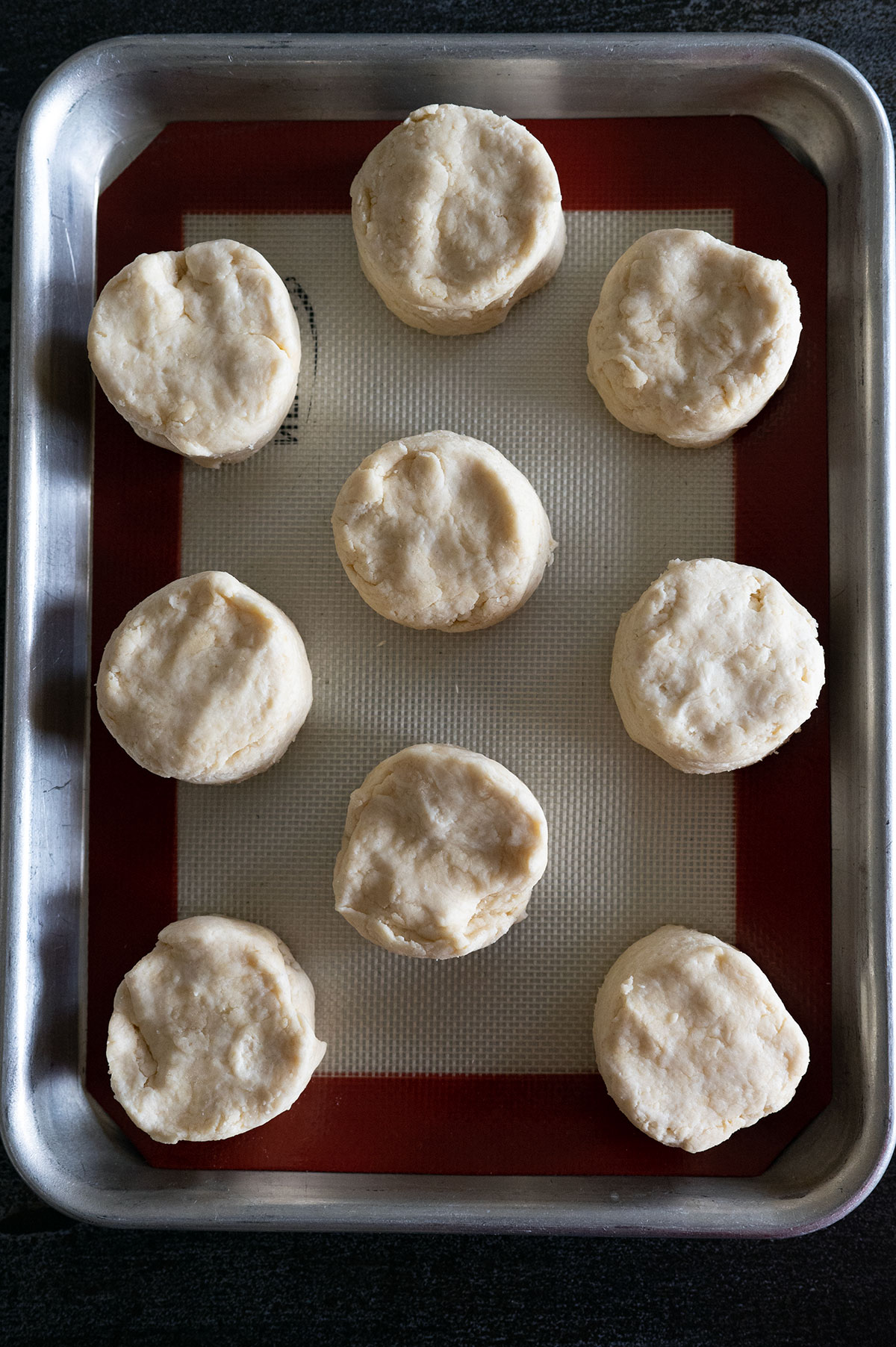 raw biscuits on silpat-lined sheet pan.