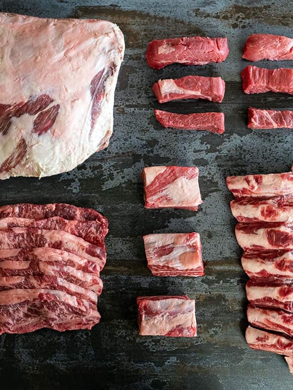 arrangement of raw beef plate ribs, flanken-cut short ribs, country style ribs, english-cut short ribs, beef back ribs.