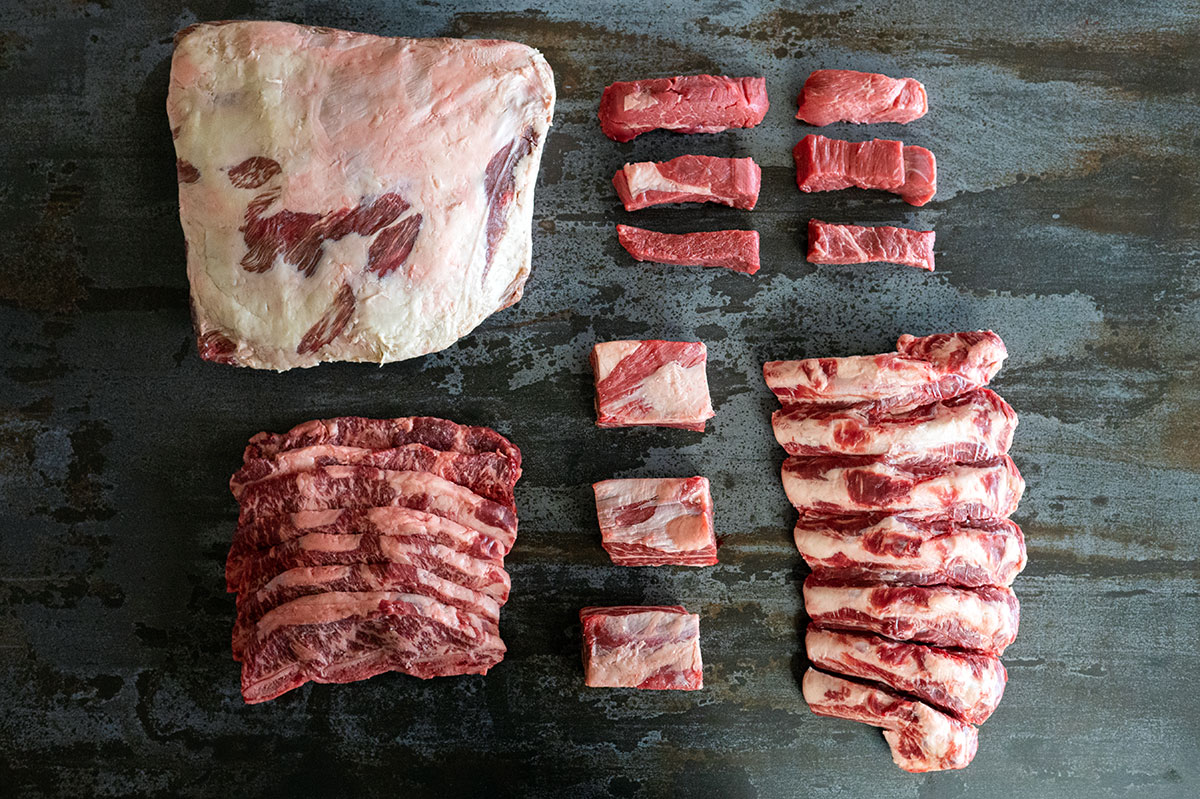arrangement of raw beef plate ribs, flanken-cut short ribs, country style ribs, english-cut short ribs, beef back ribs.