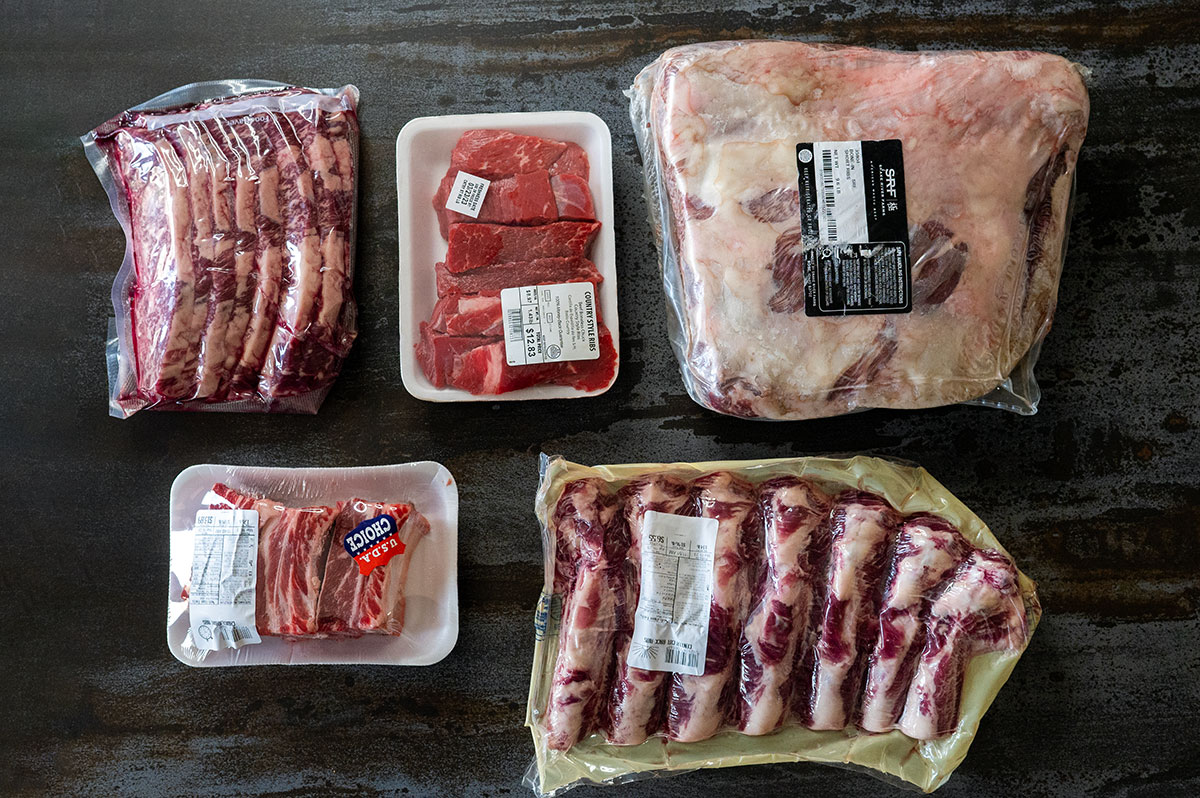 arrangement of raw beef plate ribs, flanken-cut short ribs, country style ribs, english-cut short ribs, beef back ribs in packaging.