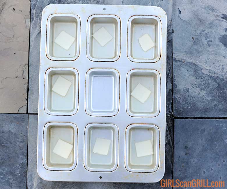 9-cavity mini loaf pan with broth and a pat of butter in each cavity
