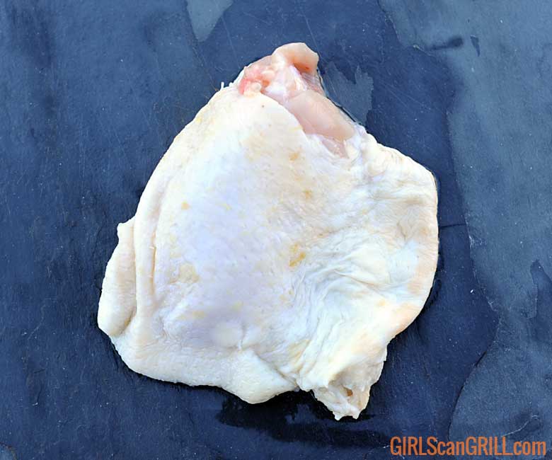 raw chicken thigh on slate tile