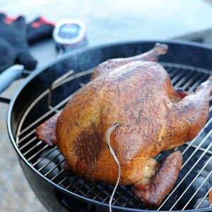 smoked turkey sitting on weber grill with igrill thermometer in breast