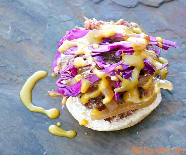 an open face lamb sandwich with red cabbage and mustard sauce