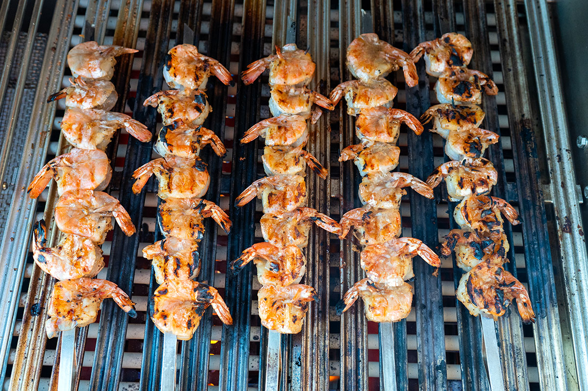 skewers of grilled shrimp on grill.