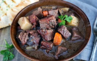 wooden bowl full of pot roast with grilled bread