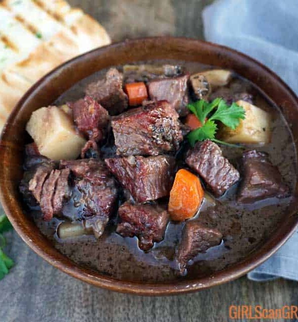 wooden bowl full of pot roast with grilled bread