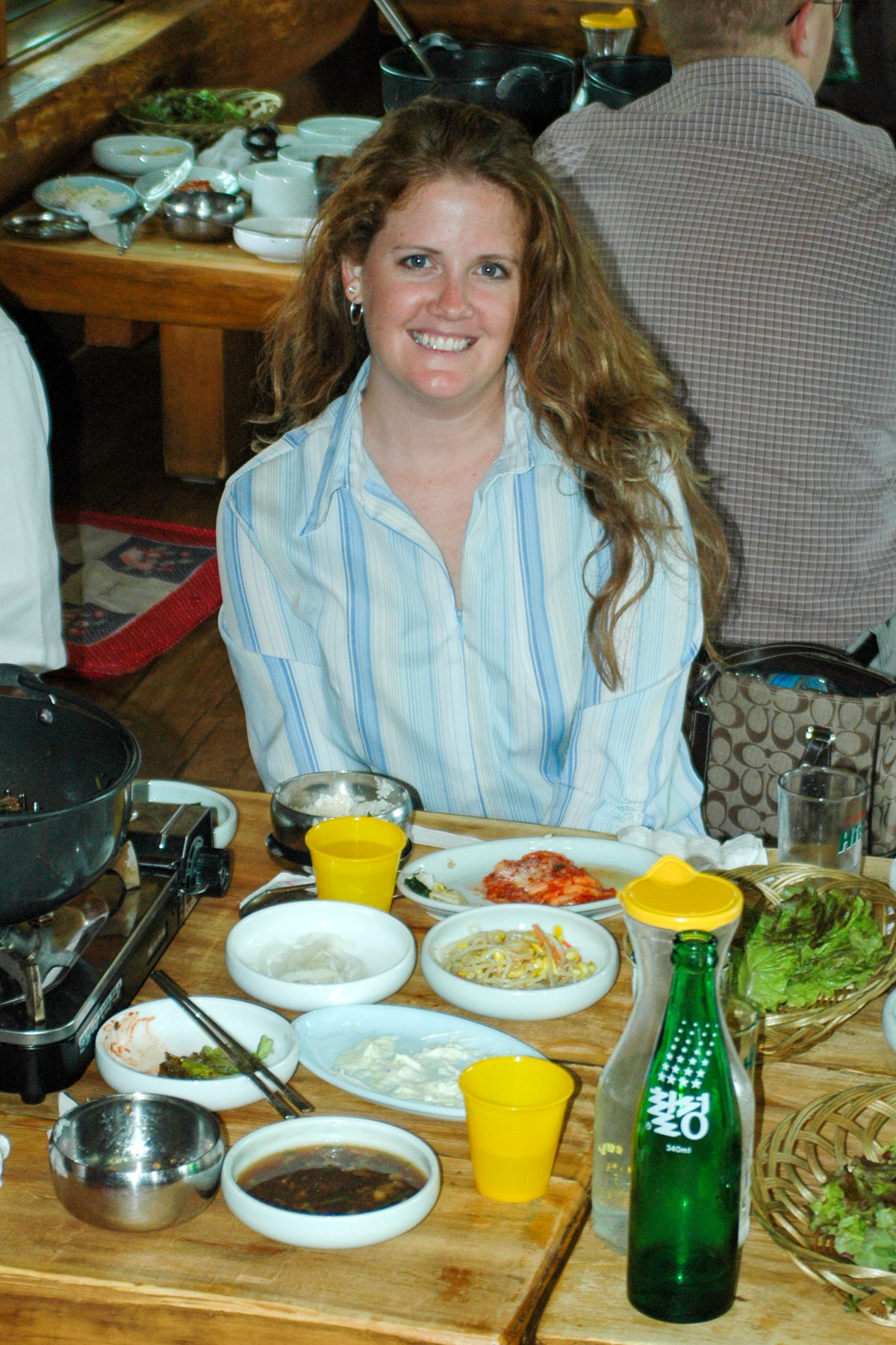 woman sitting at a table with Korean food.