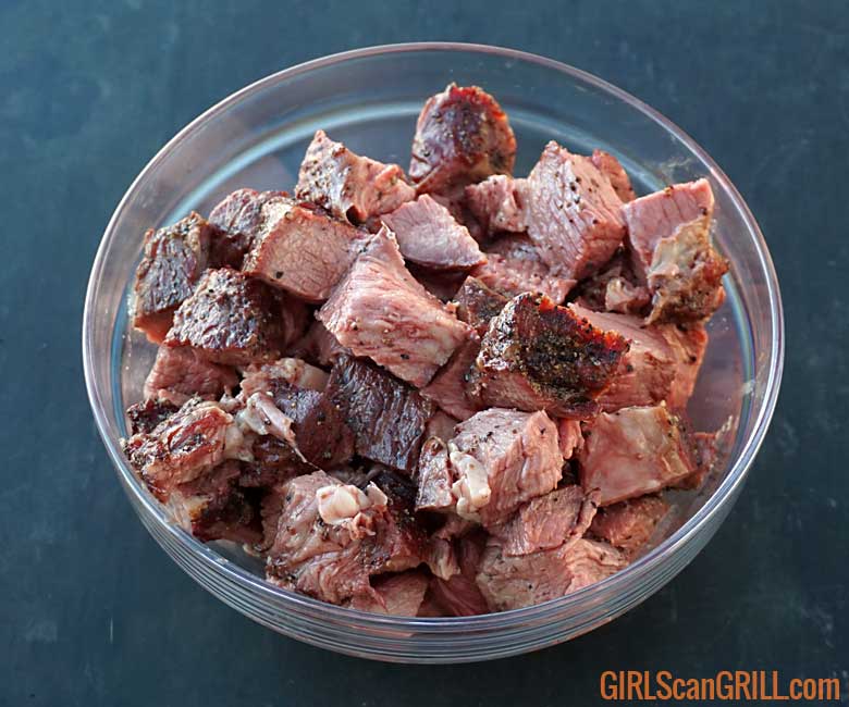 glass bowl full of sliced beef on black table