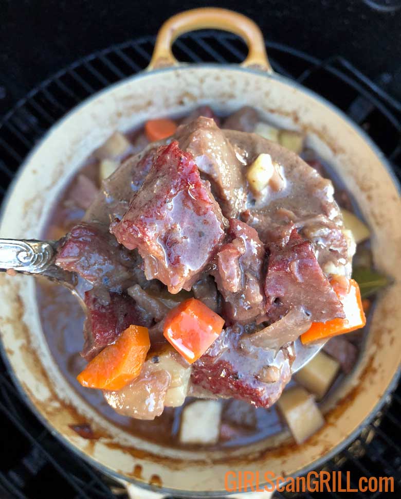 ladle of pot roast over pot on grill