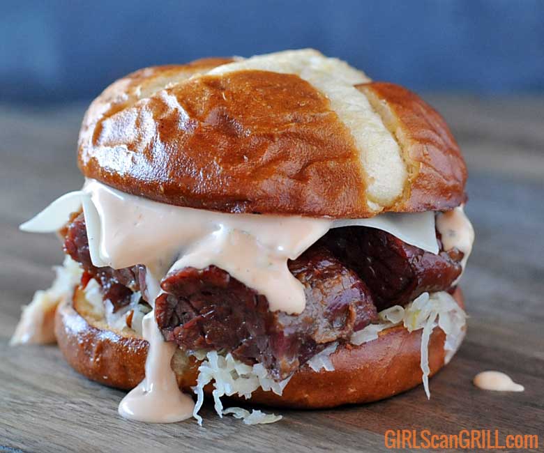 corned beef burnt ends sandwich on pretzel bun with russian dressing dripping