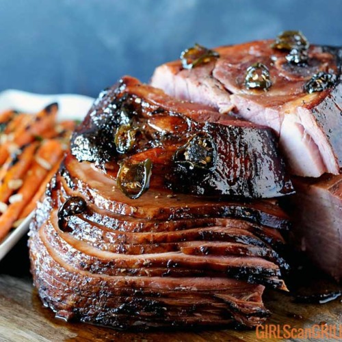 spiral sliced ham on wood platter with carrots to left